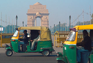 Indien 2005 - New Delhi - Indian Gate mit Baldachinsäule im Vordergrund. Allgegenwärtige Autorikscha's (Tuk-Tuk's) rasen vorbei